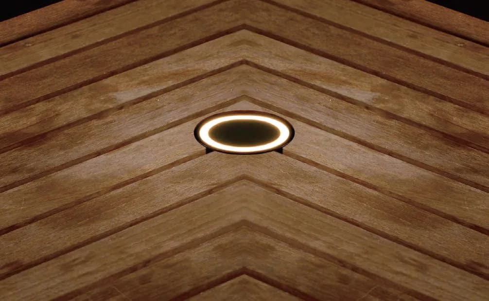 Round in-ground light set flush into a timber deck