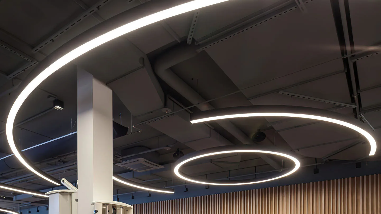 Bendable aluminium profile formed into rings of light on an open ceiling