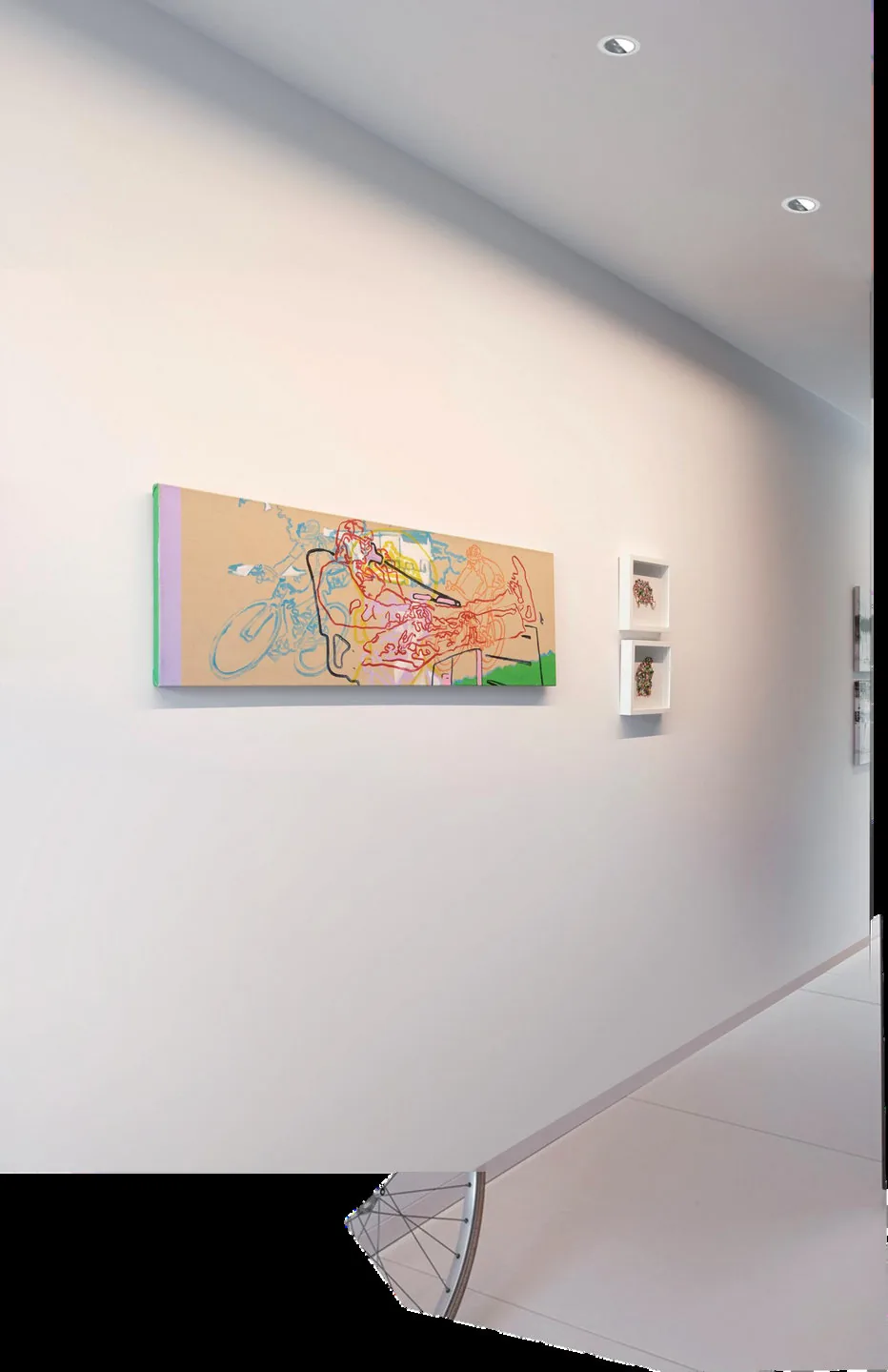 Gallery wall with paintings lit by adjustable recessed spotlights