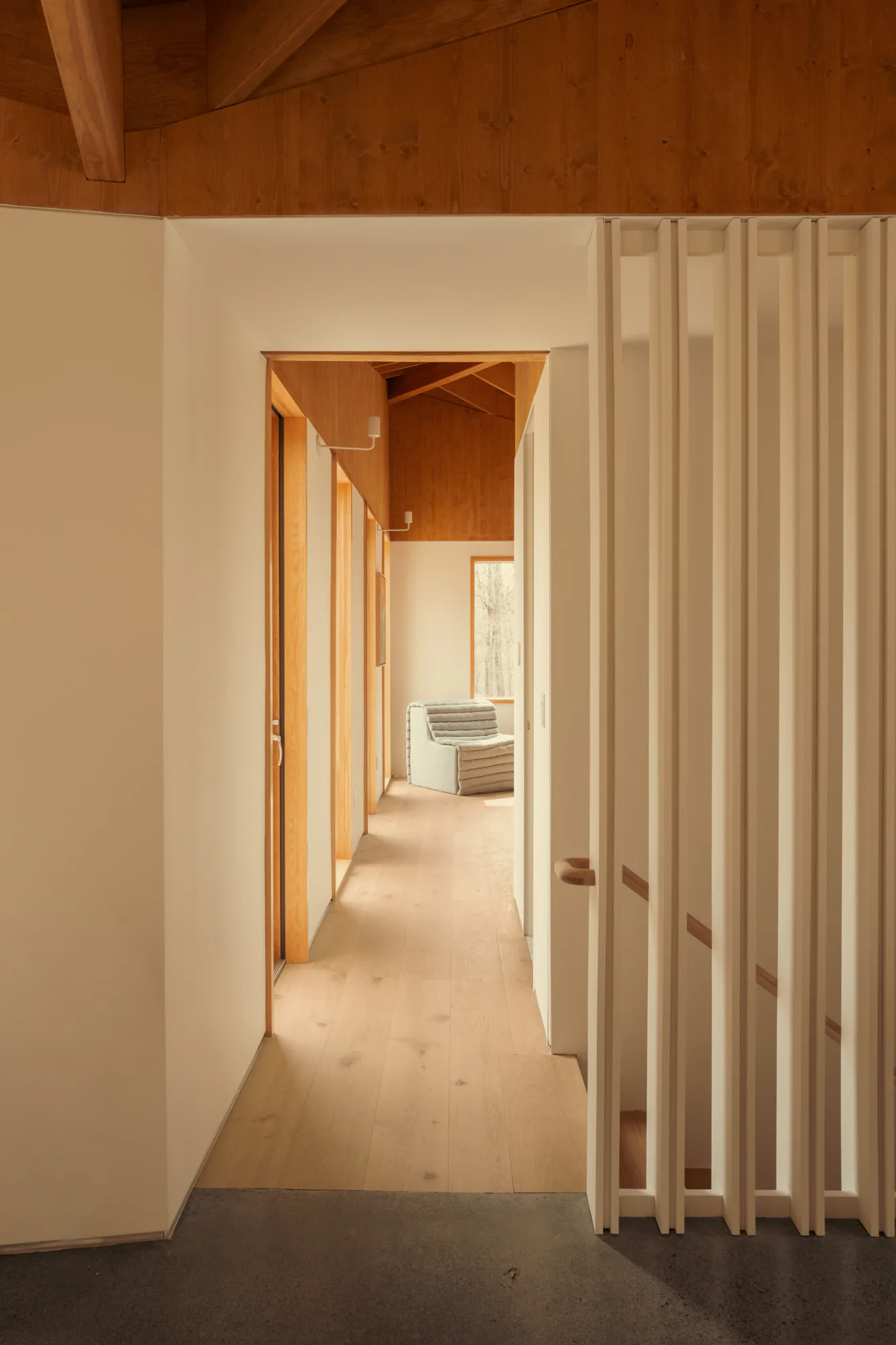Corridor beside a floor to ceiling slatted timber screen