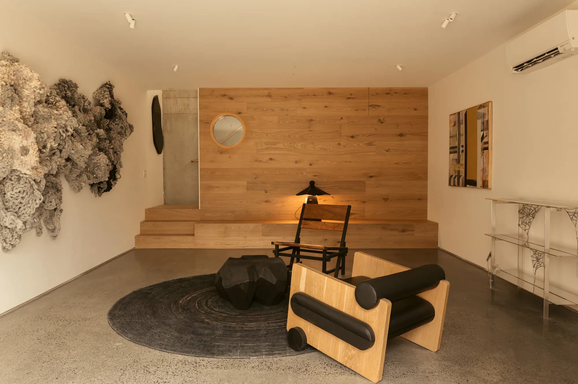 Media room with a timber-clad wall and raised platform, lit by small recessed spots