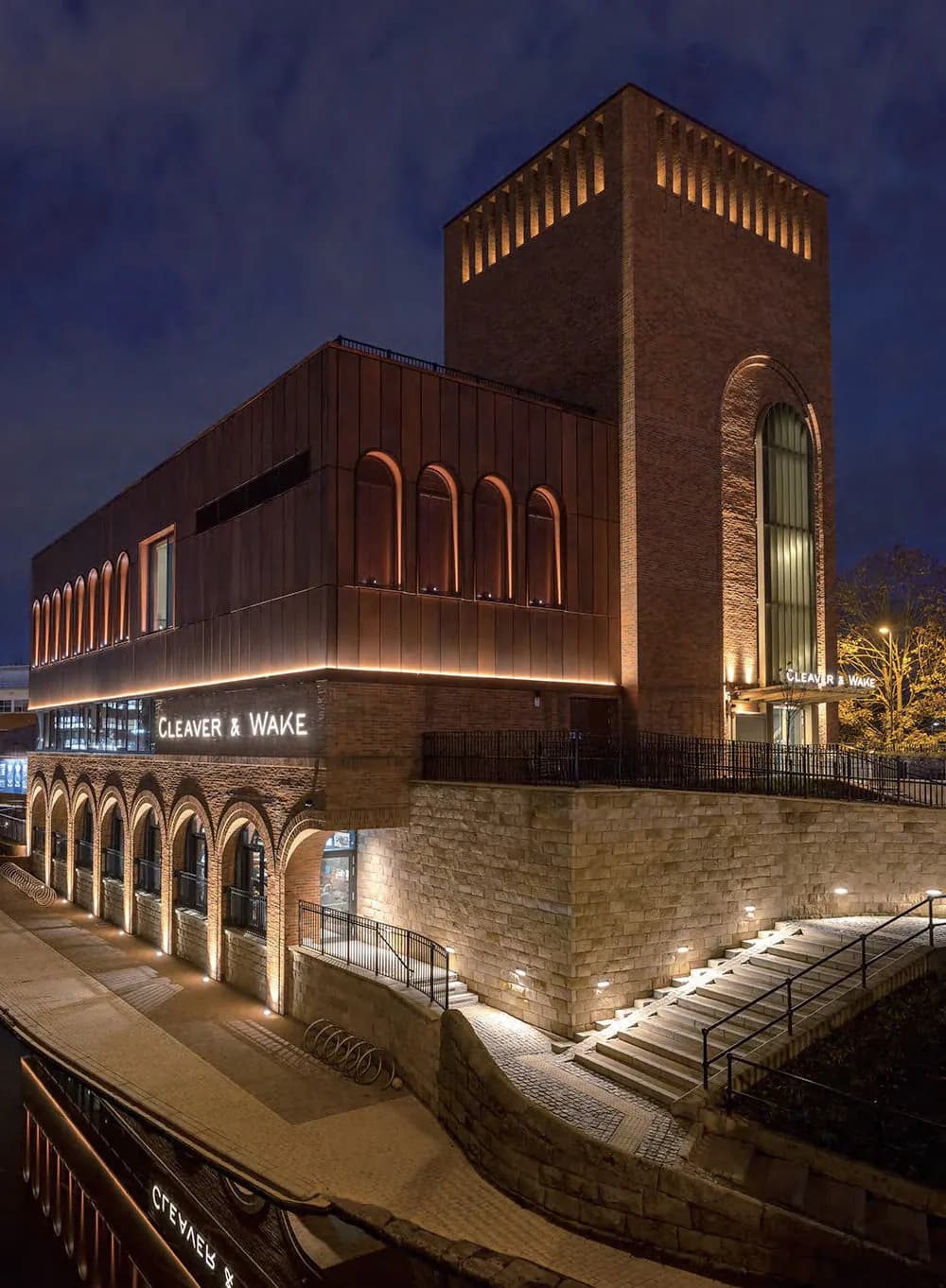 Brick building at dusk with its facade washed by floodlights