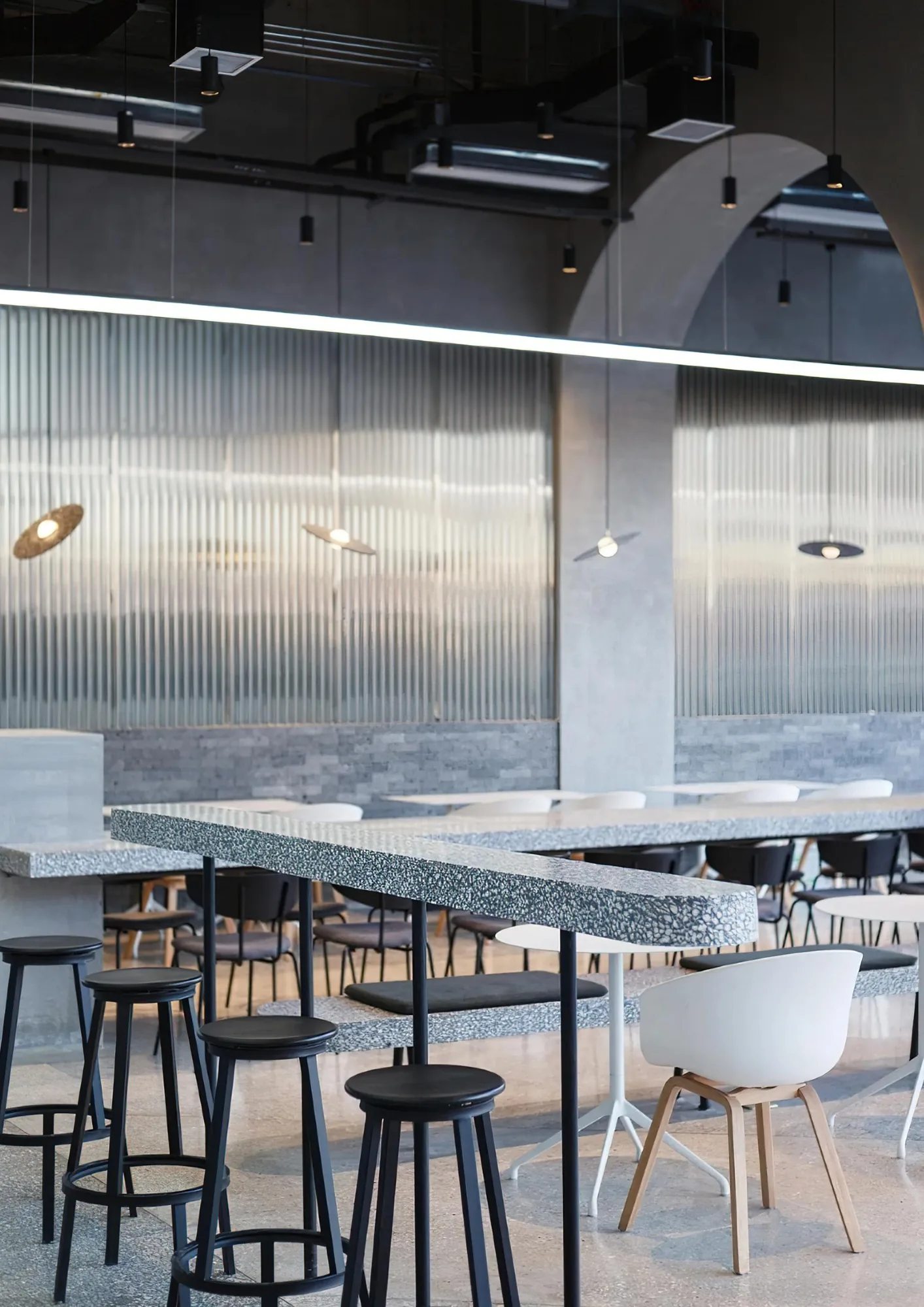 Restaurant with cylinder pendants over the tables and a linear light above the bar