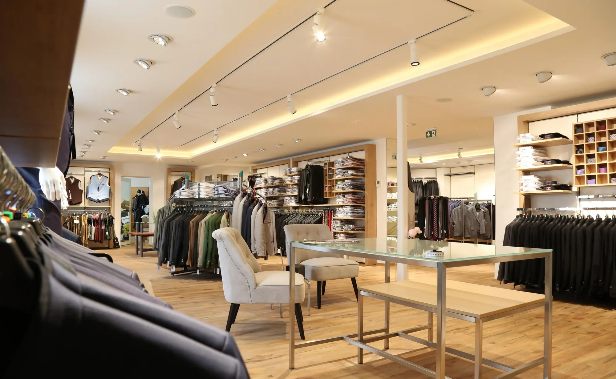 Menswear store with surface track heads aimed across the racks