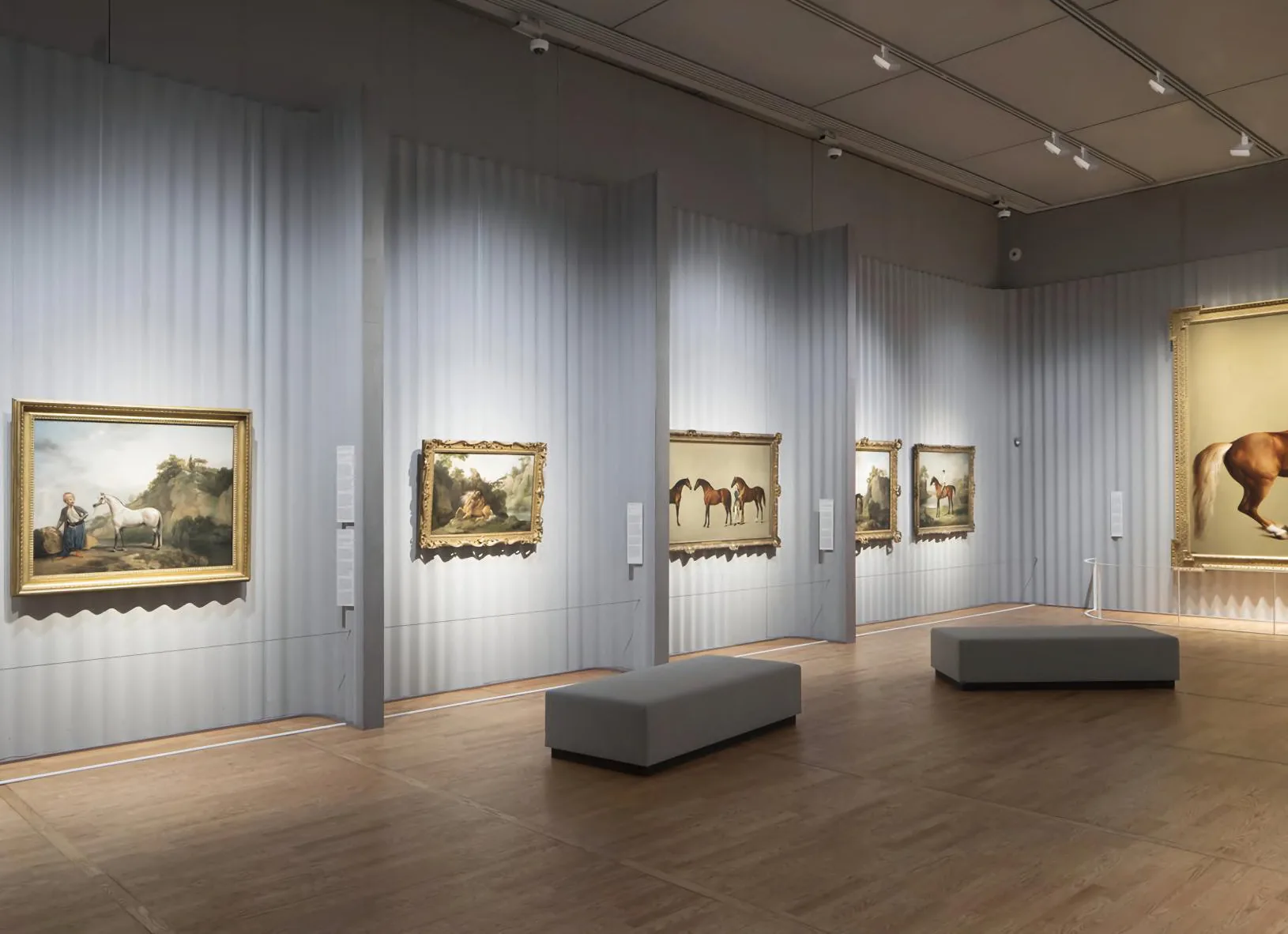 Gallery with paintings lit by track spotlights
