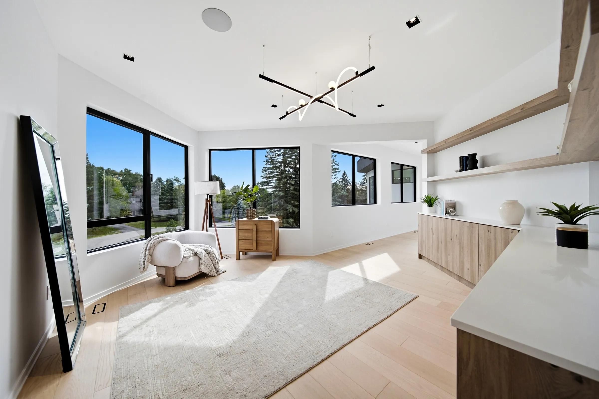 Dressing area in the primary suite with the linear pendant and sculpted neon loop overhead