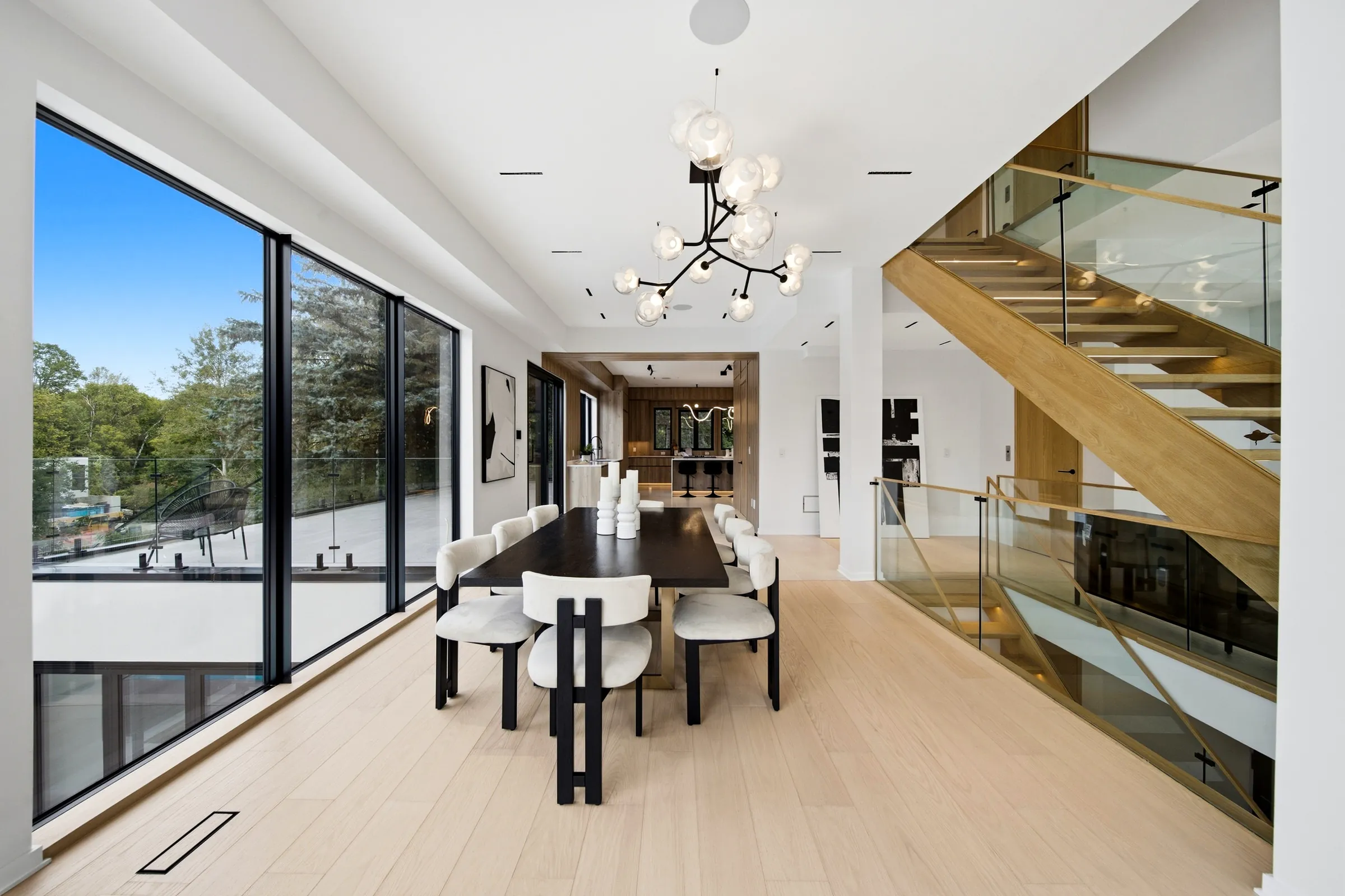 Dining room with a branching chandelier of glass globes beside the open oak stair
