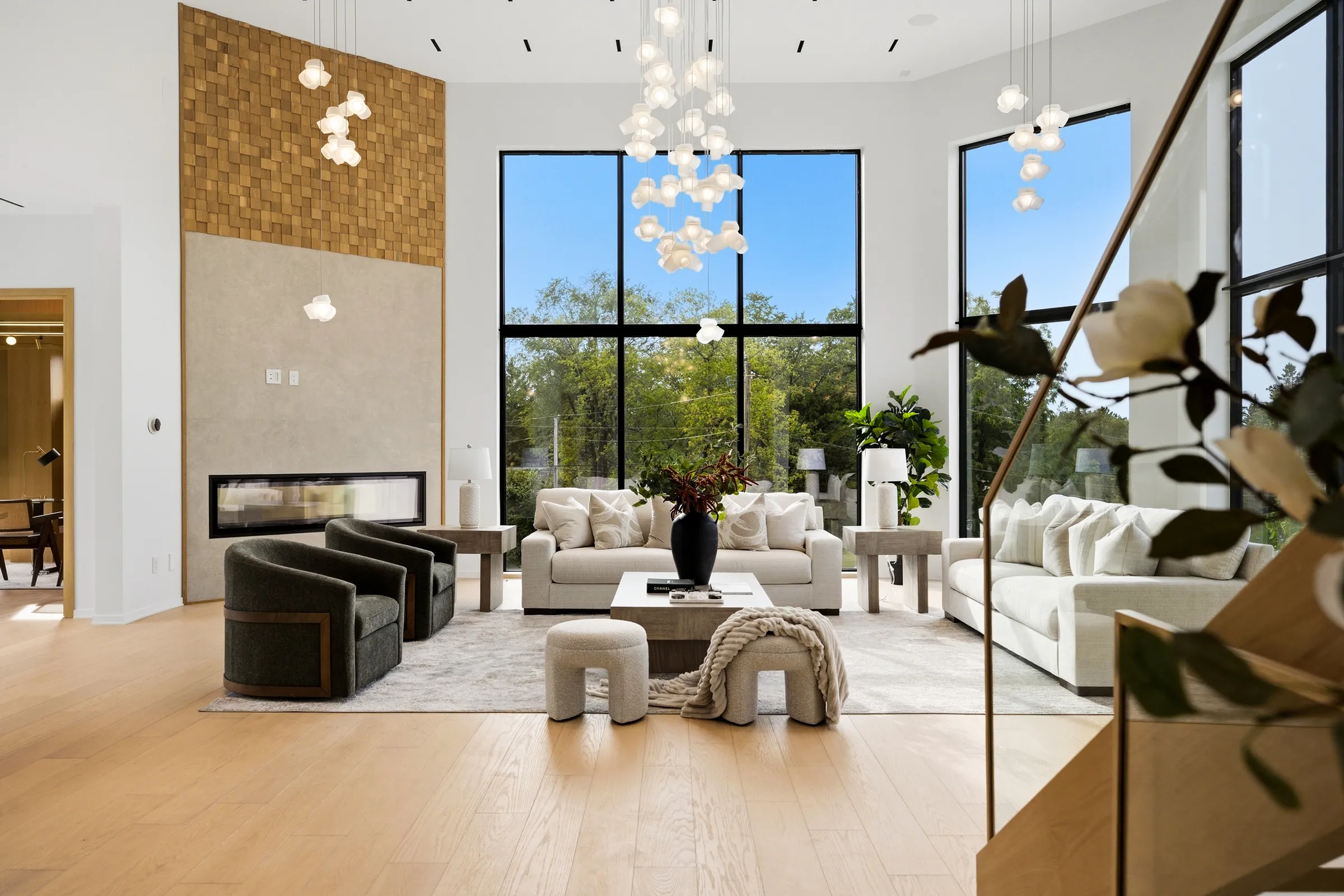 Great room from the stair landing, globe pendants at eye level against the window wall