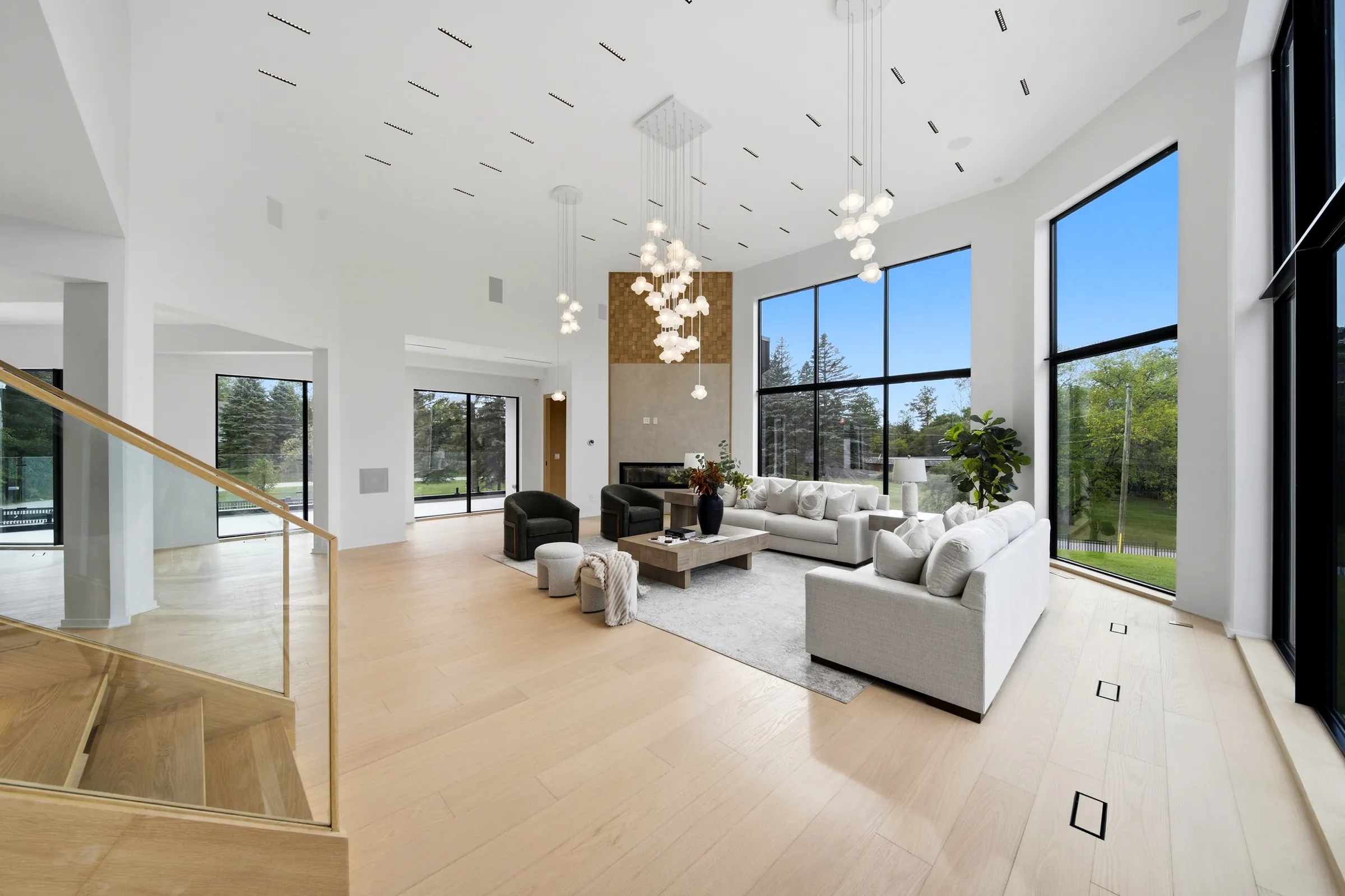 Great room from the upper stair, the pendant cluster dropping through the double height volume