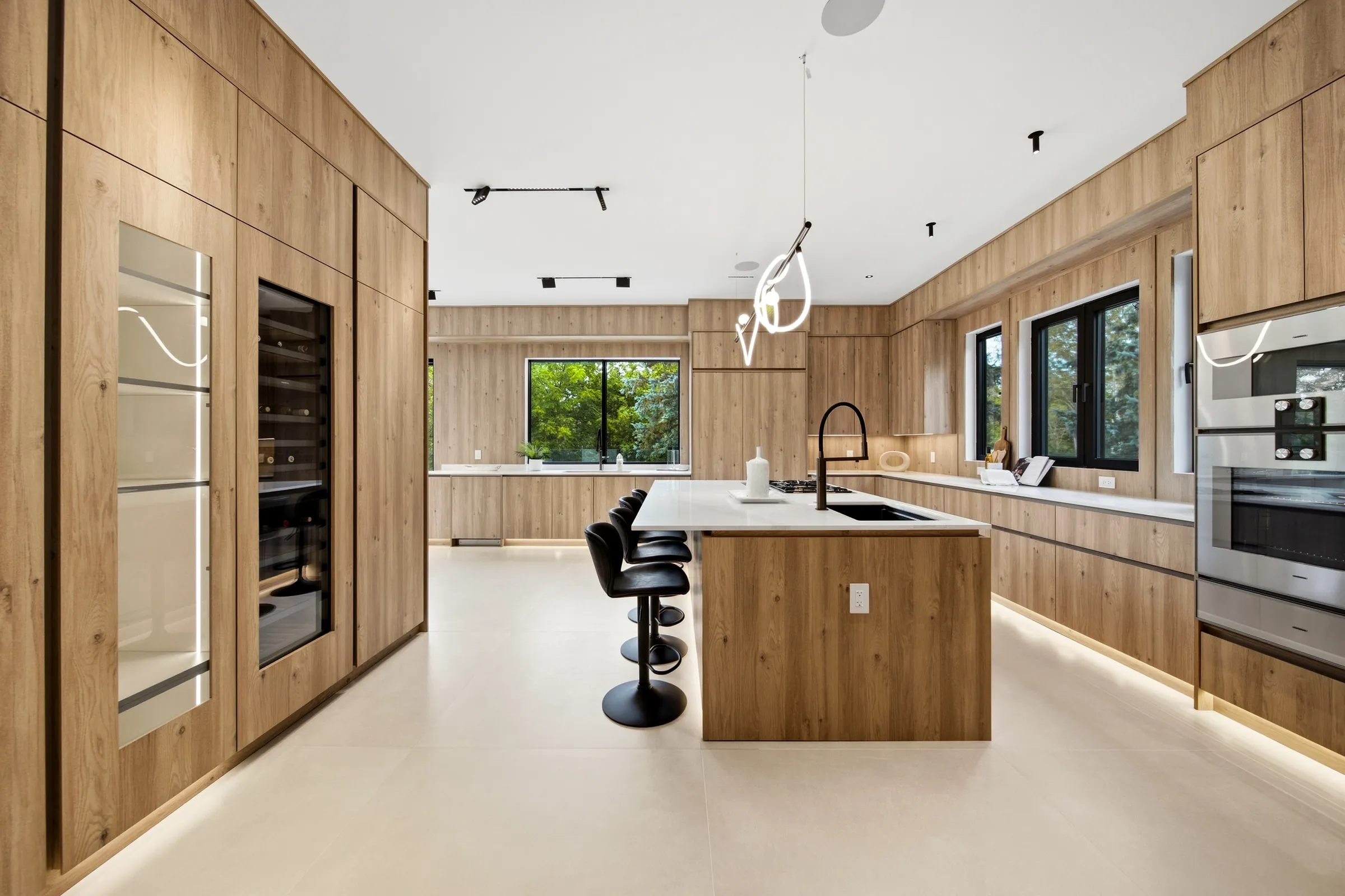 Kitchen from the wine fridge end, island toe kick lighting and the pendant over the counter