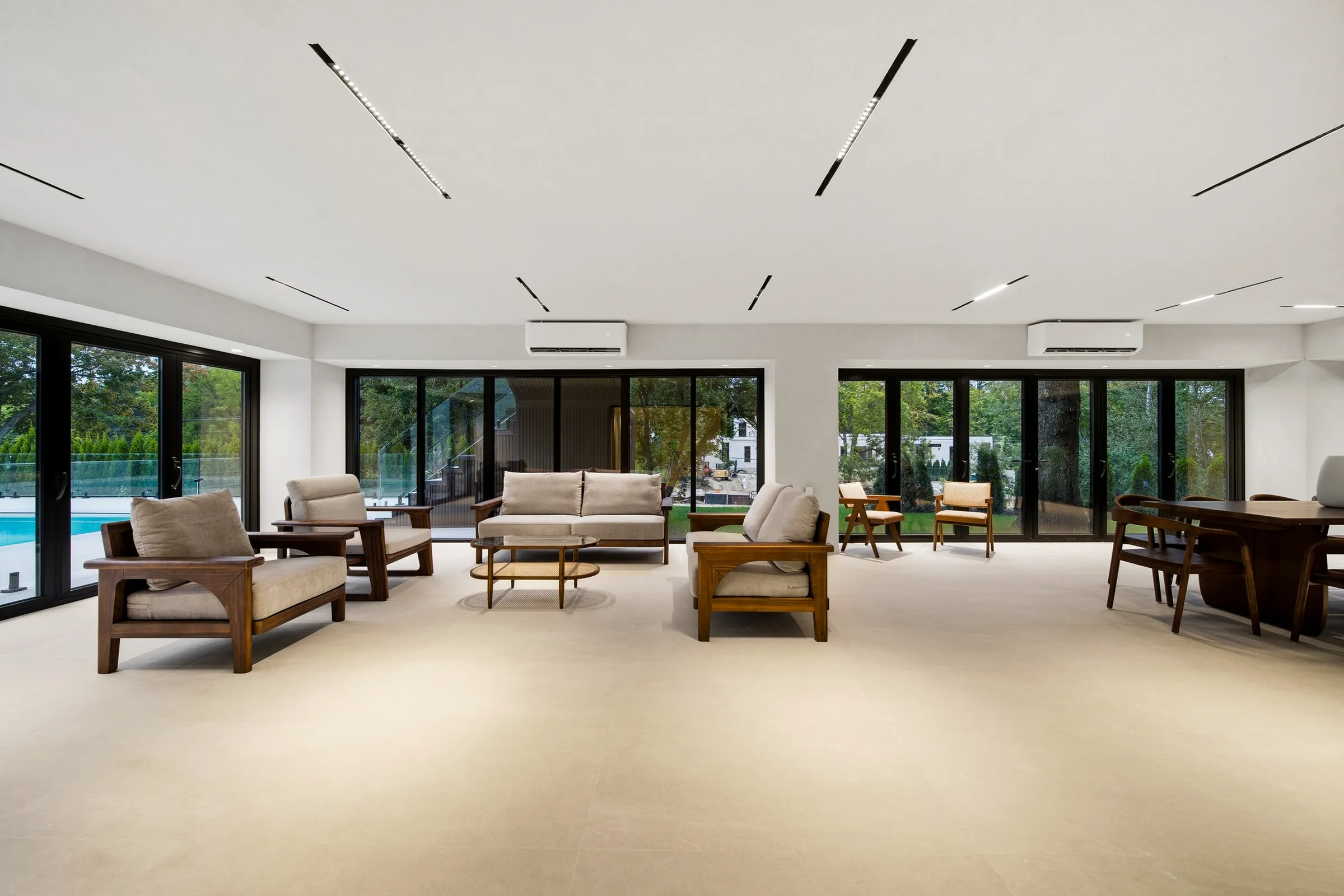 Lower level lounge with recessed linear ceiling slots and glazing across the whole wall