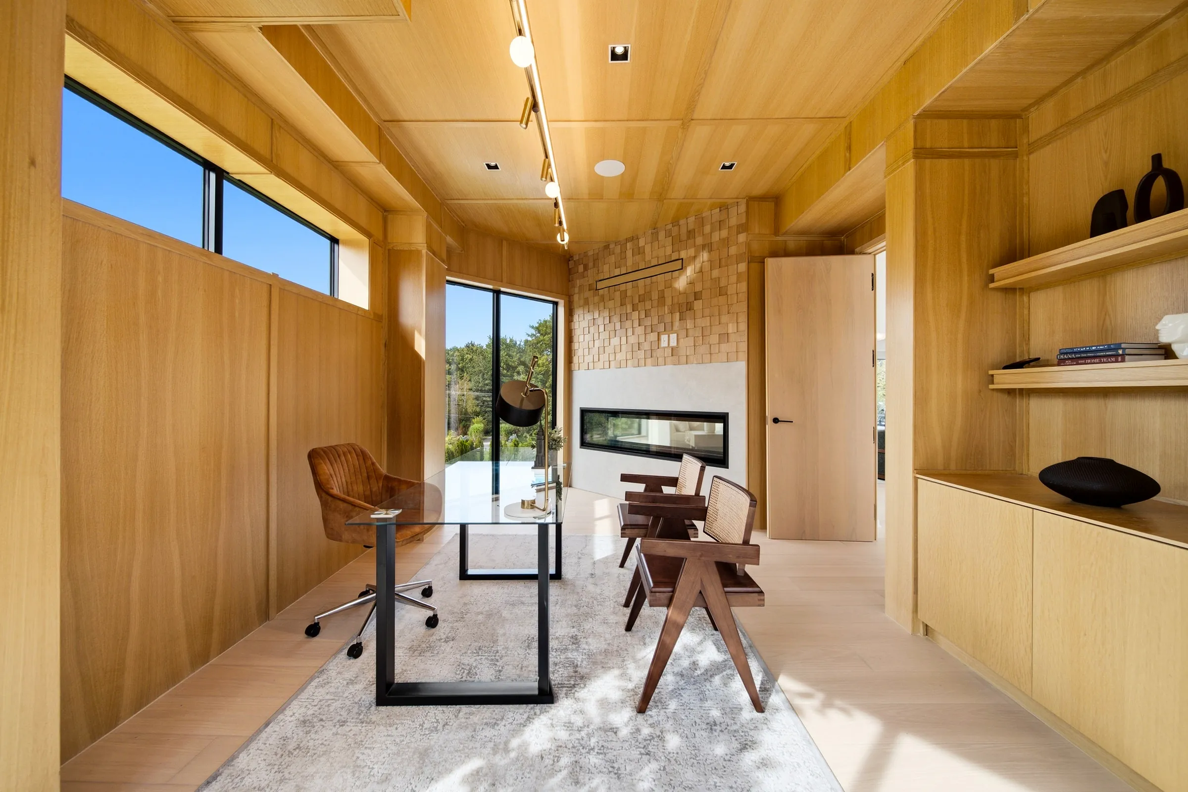 Study toward the fireplace, track spots on the oak ceiling and a recessed downlight over the shelves