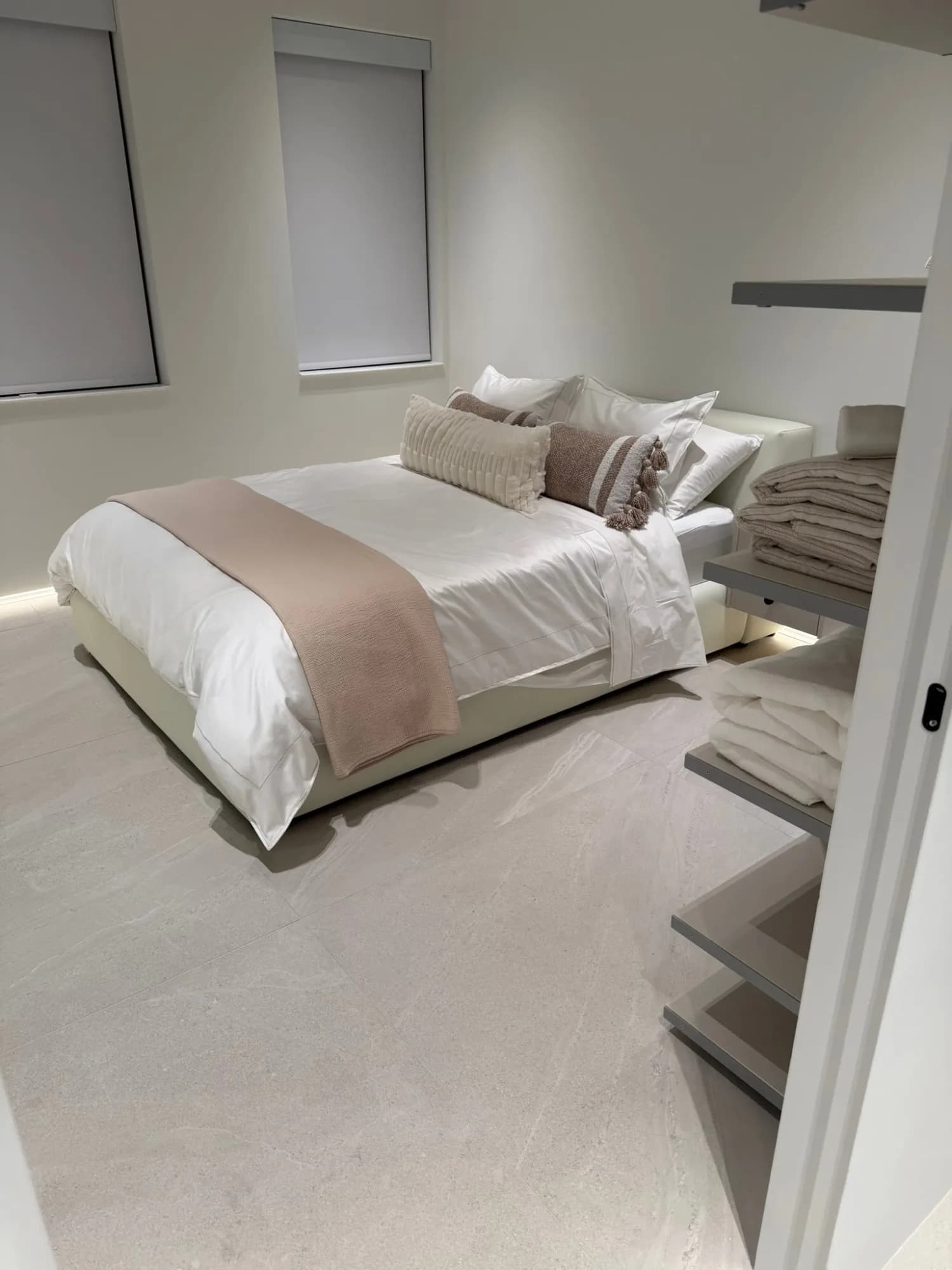 Guest bedroom in white and sand tones with a lit skirting line