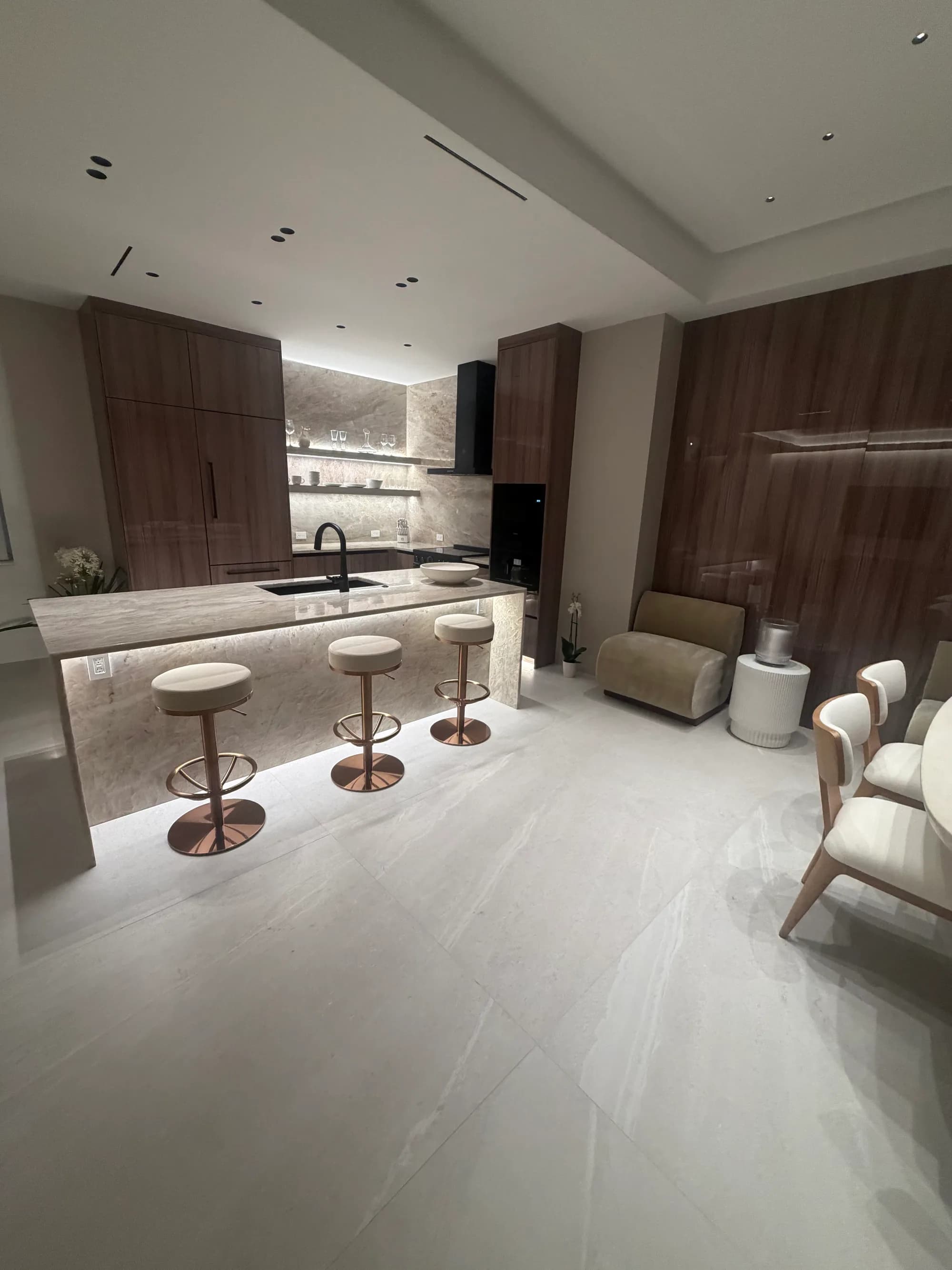 Kitchen island with three stools under recessed downlights