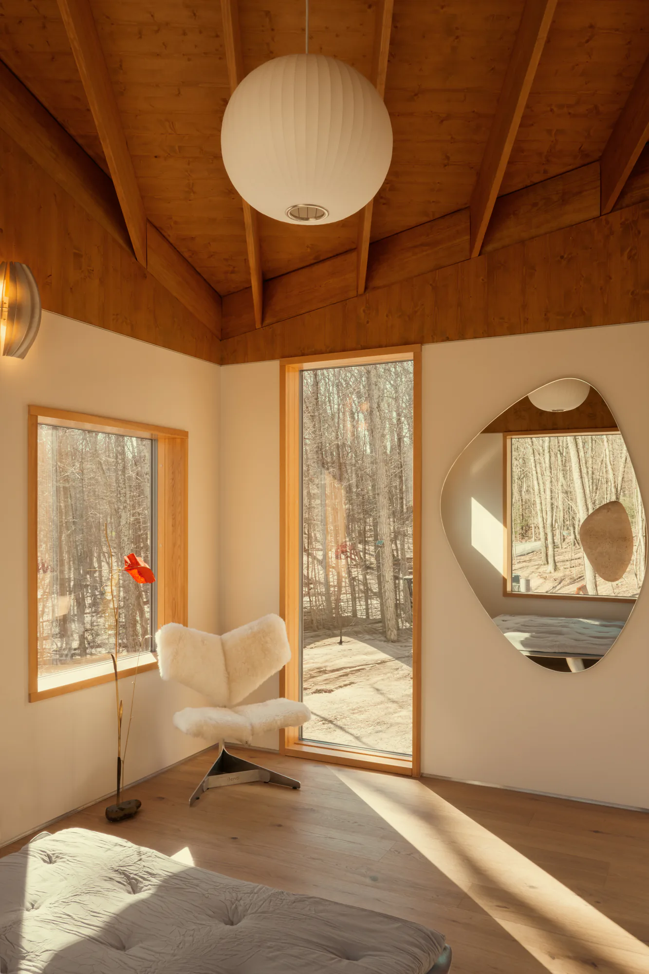 Second bedroom with a paper lantern, wide window onto the trees